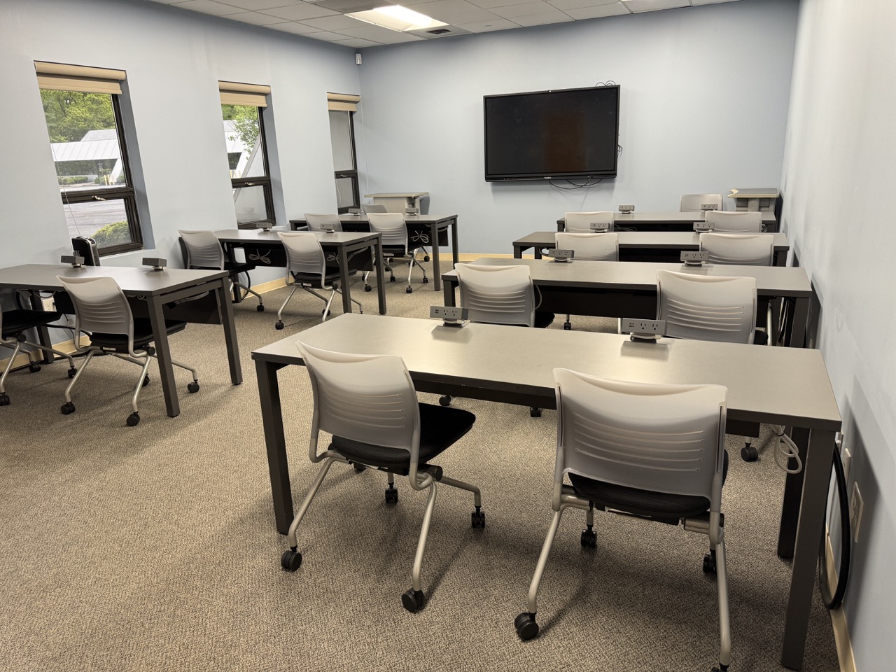 room with tables and chairs, smartboard on wall